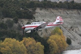 A classic biplane soaring above a scenic landscape during a ferry flight.