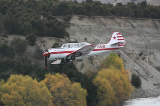Vintage racing airplane soaring over a sepia-toned Austrian landscape