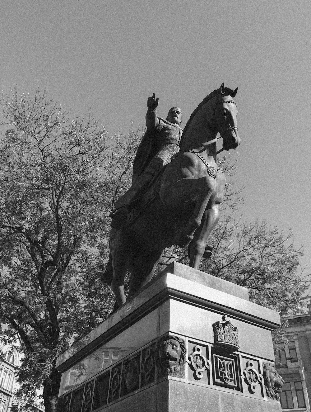 man riding horse statue in grayscale photography