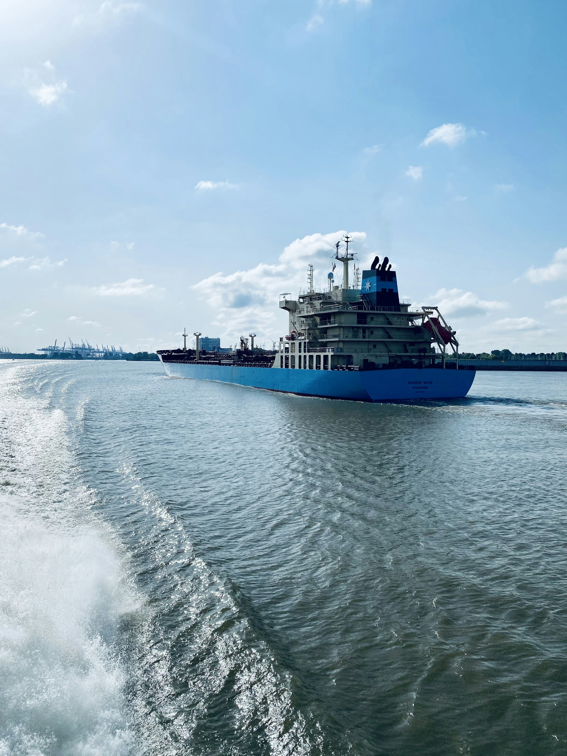 blue and white ship on sea under white clouds and blue sky during daytime