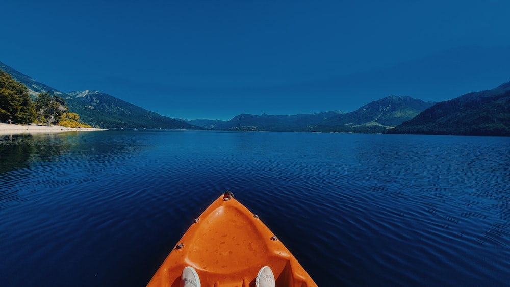 orange kayak on calm water during daytime