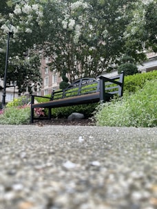 A sleek metal frame patio bench with cushions placed beside a garden path.