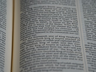 A close-up of an open book displaying printed text in English. The focus is on the center portion of the page, highlighting a passage with a mention of 'Moses' and 'LORD'. The text is formatted in two columns.