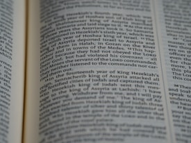 A close-up of an open book displaying printed text in English. The focus is on the center portion of the page, highlighting a passage with a mention of 'Moses' and 'LORD'. The text is formatted in two columns.