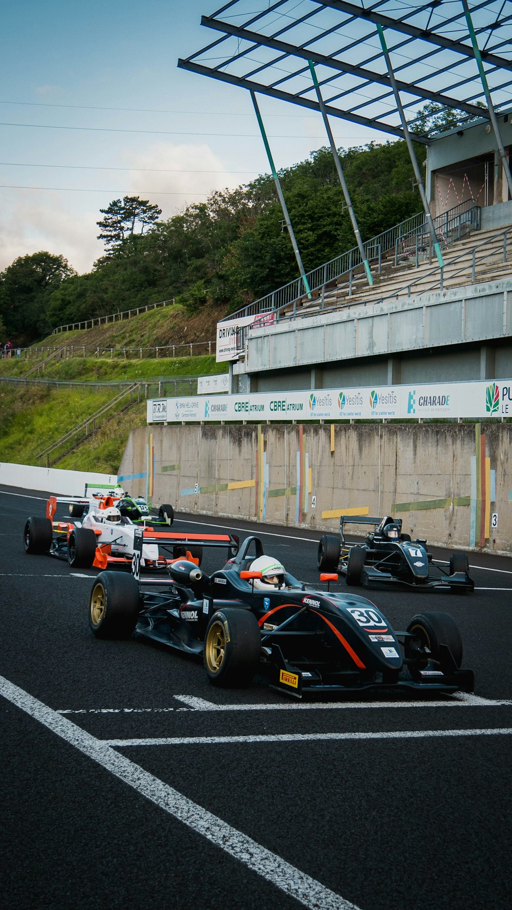 black and red f 1 car on gray asphalt road during daytime