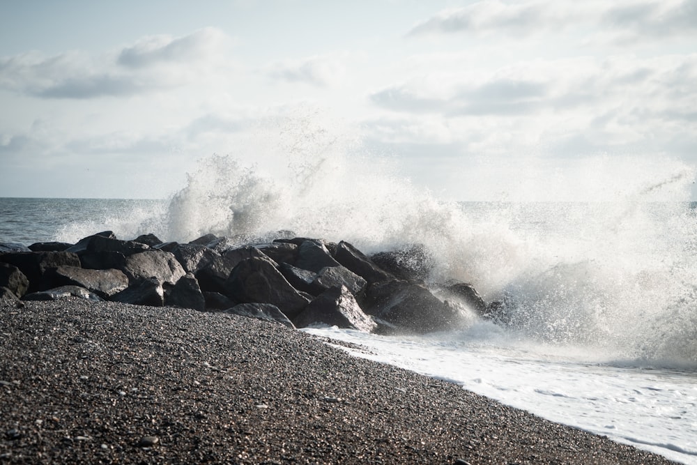 ocean waves crashing on rocky shore during daytime