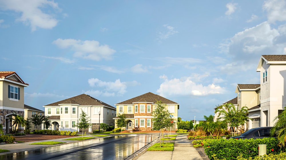 white and brown house near green trees under blue sky during daytime