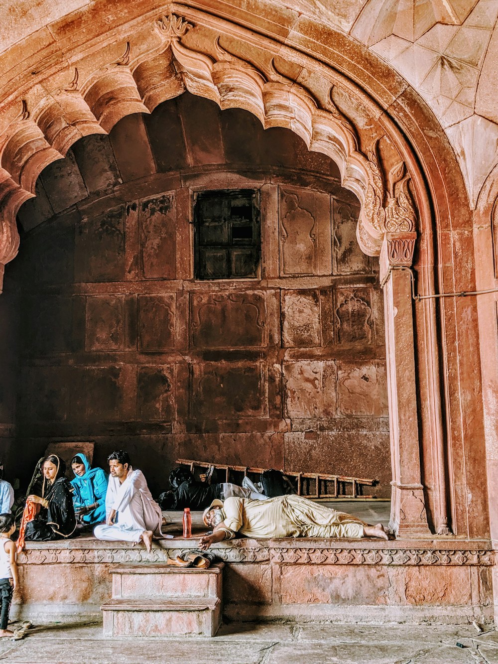 man and woman sitting on bed near brown brick building during daytime