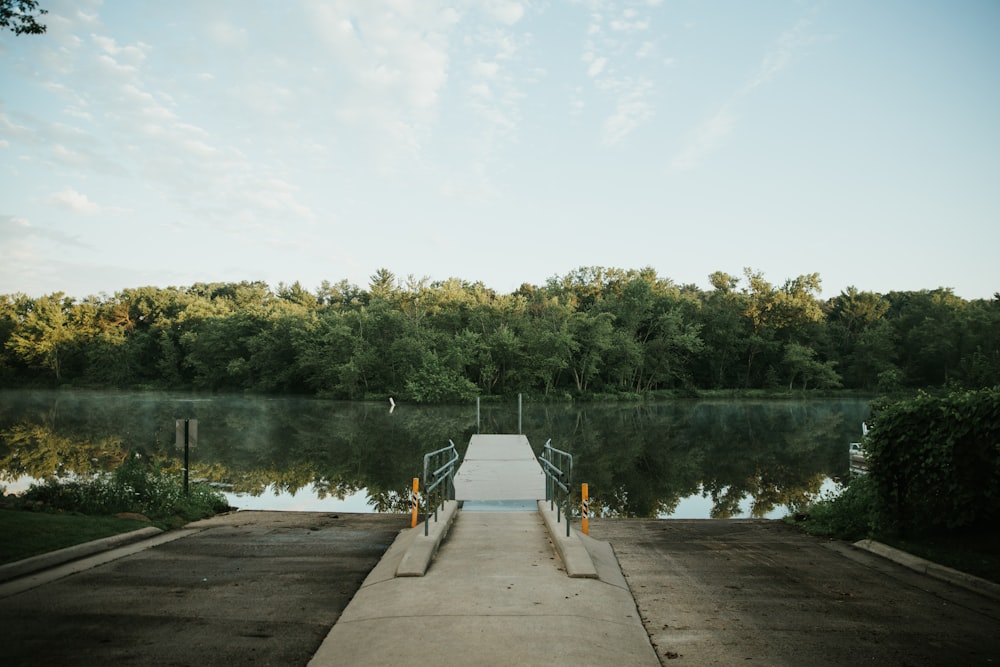 person in gray jacket standing on dock during daytime