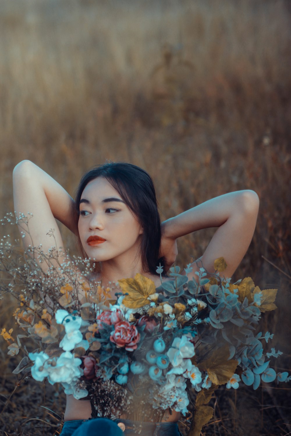 woman in white floral dress lying on brown grass field