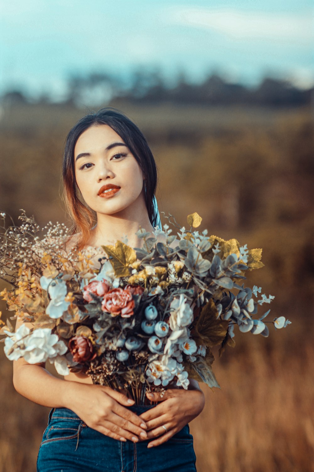 mujer en vestido floral blanco sosteniendo ramo de flores