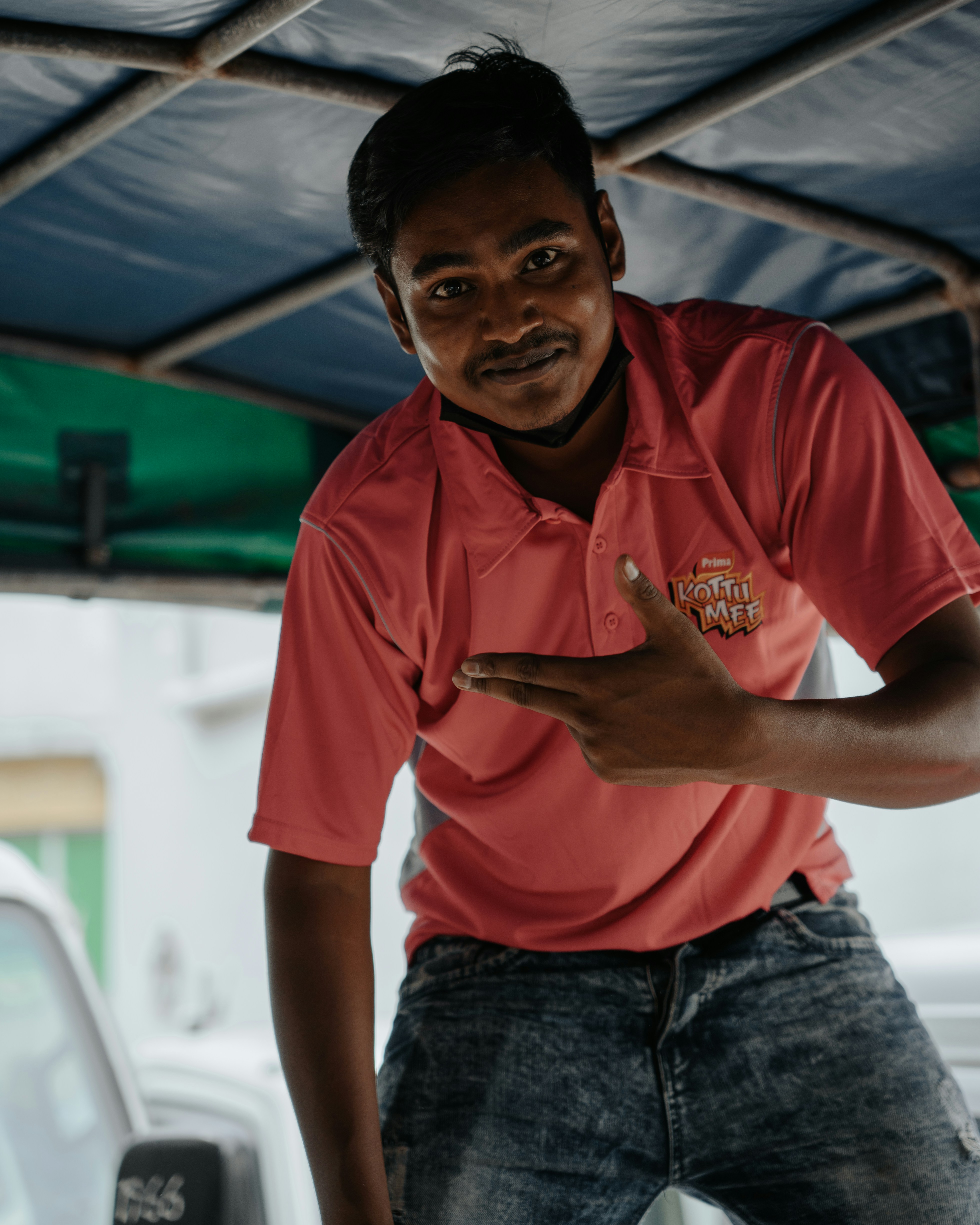 man in red polo shirt and blue denim jeans