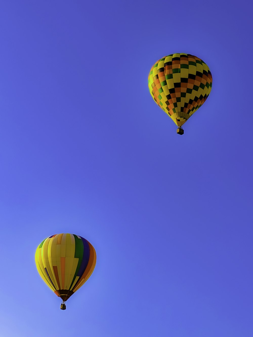 globo aerostático amarillo, verde y rojo en el aire bajo el cielo azul durante el día