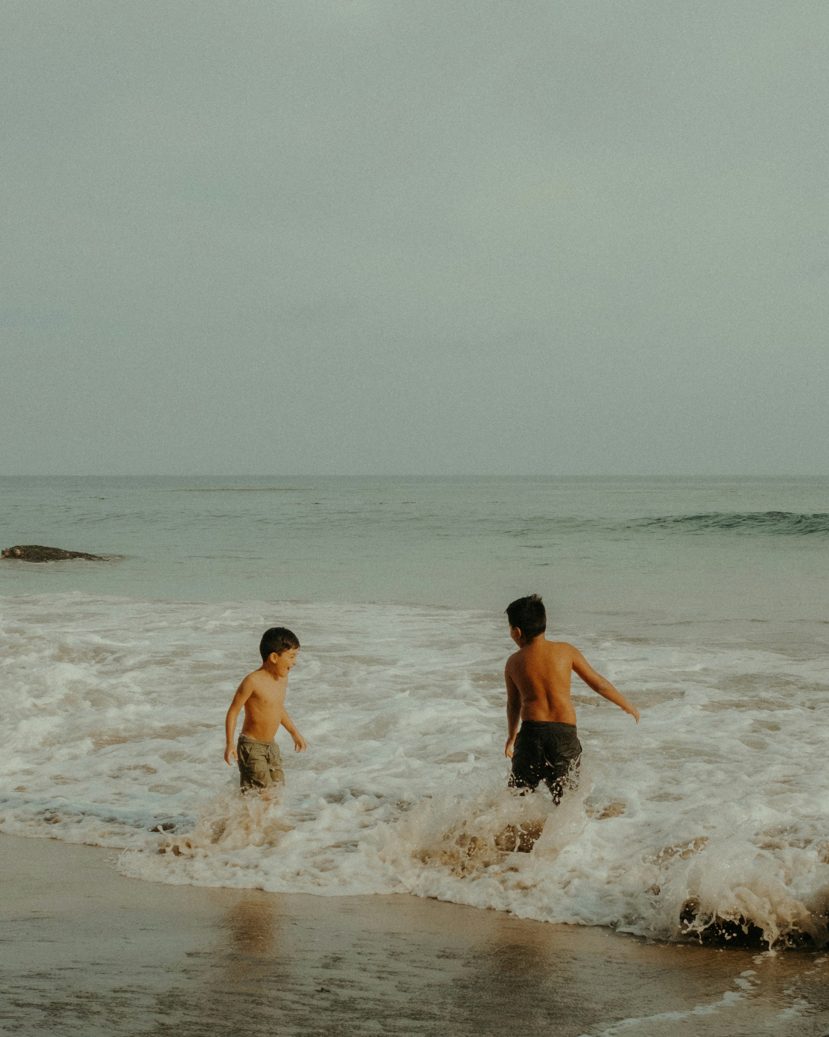 3 boys in water during daytime