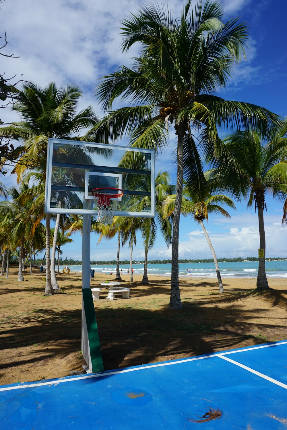 white and red basketball hoop on beach during daytime