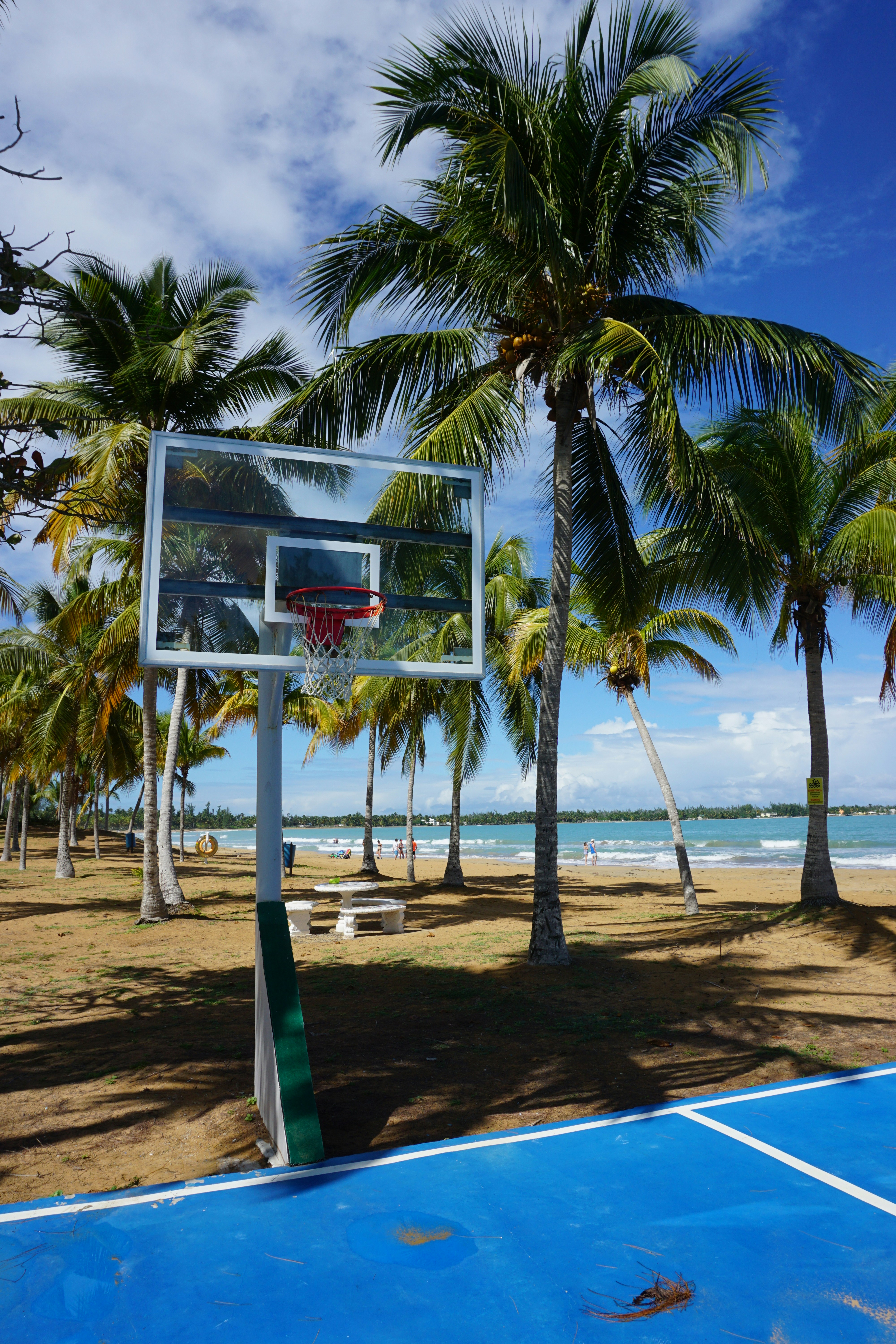 white and red basketball hoop on beach during daytime