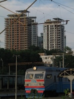 white and red train on rail near high rise building during daytime