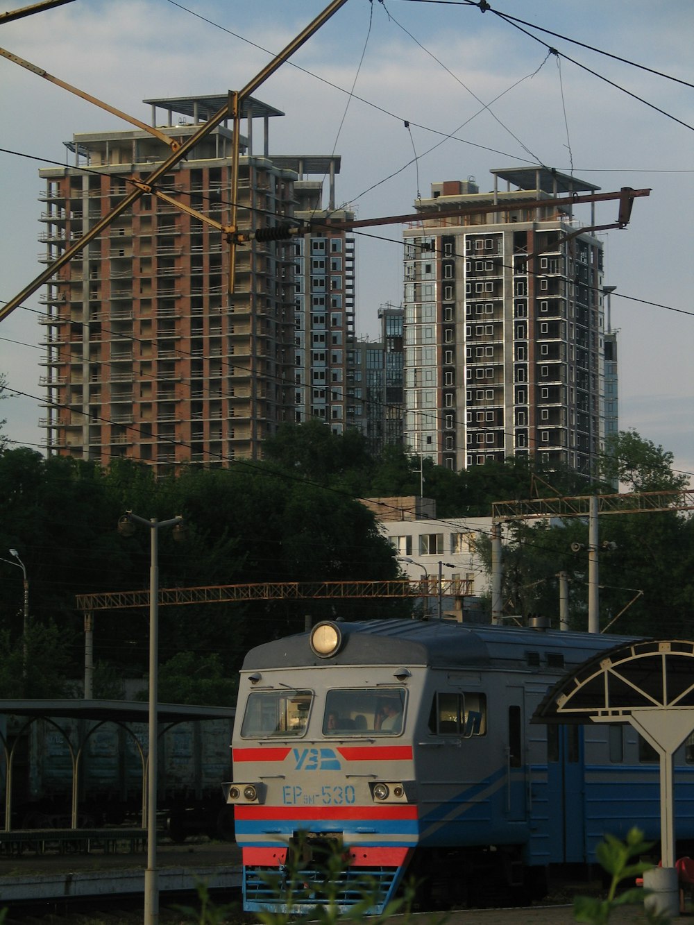white and red train on rail near high rise building during daytime