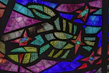 Artisan carefully assembling colorful glass pieces for a personalized memory vitral.