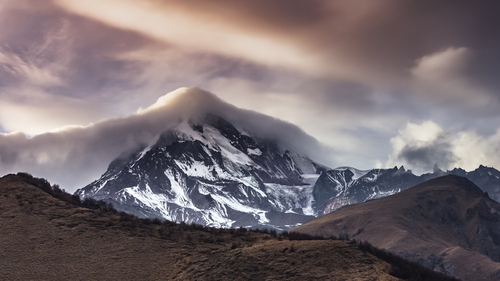 snow covered mountain under cloudy sky during daytime