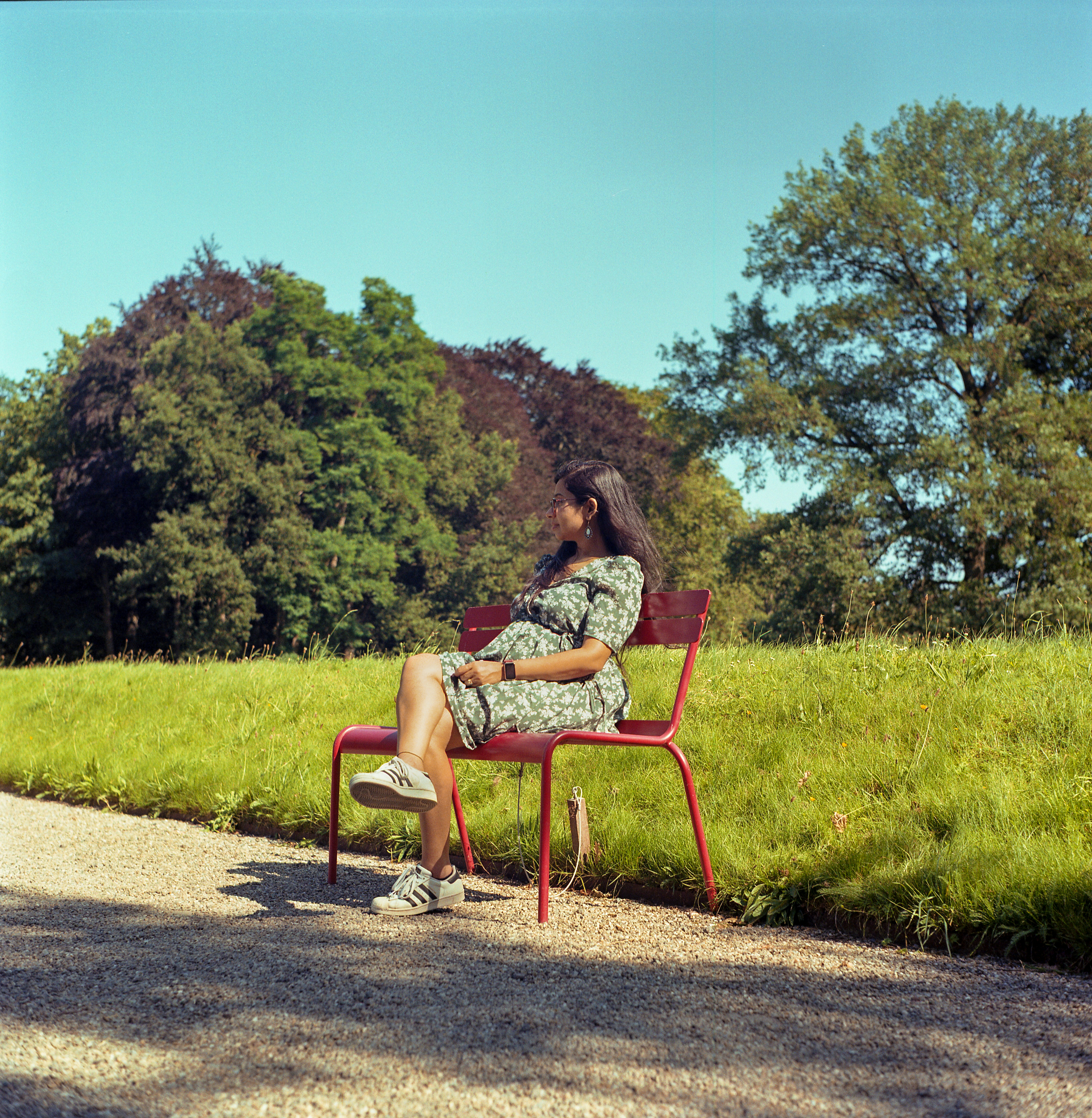a woman sitting on a bench in a park