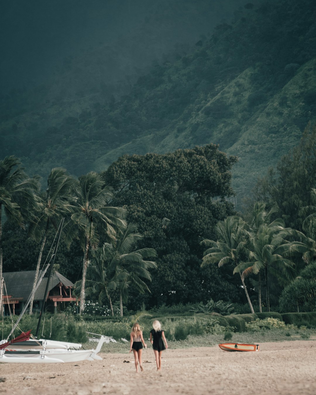 people sitting on white and red lounge chairs near green trees and mountain during daytime