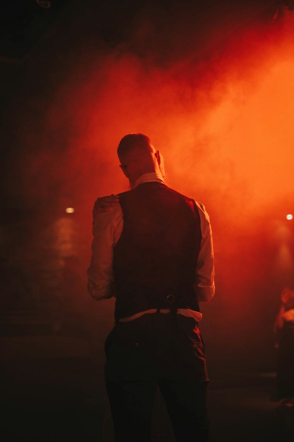 man in black vest standing on stage