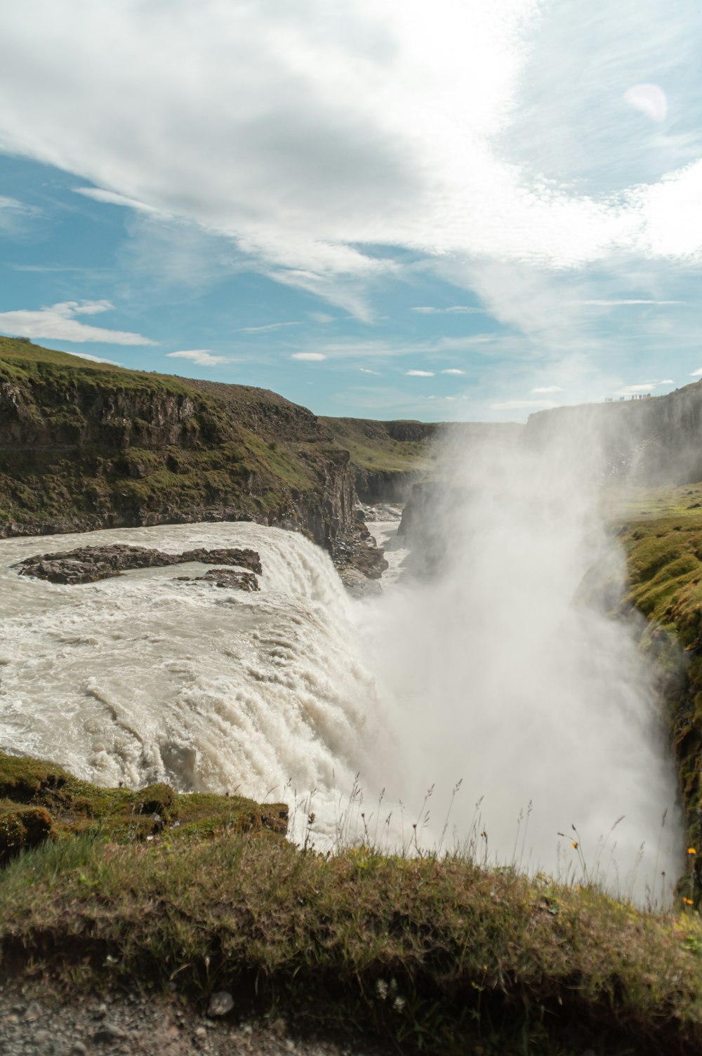 waterfalls under white clouds and blue sky during daytime