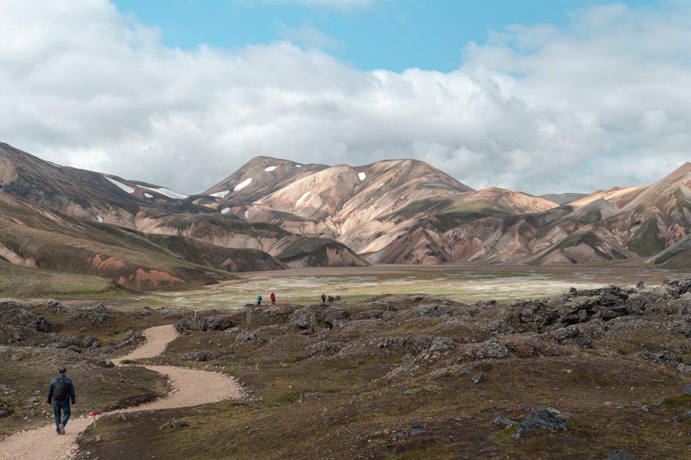 brown and gray mountains under white clouds and blue sky during daytime