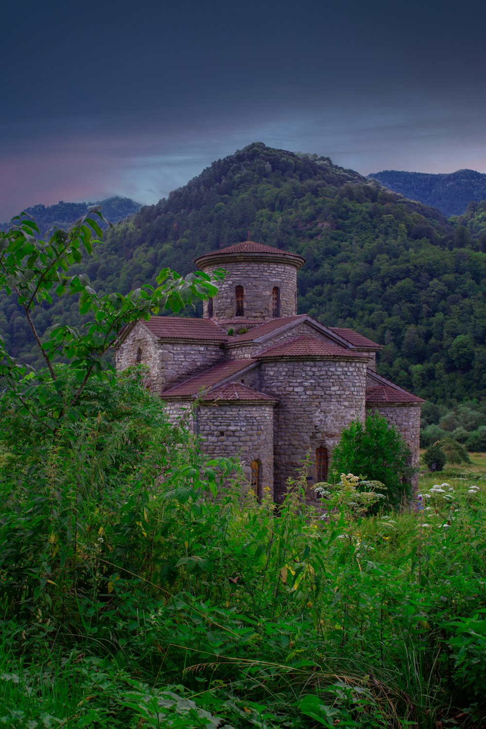 edificio in mattoni marroni su un campo di erba verde durante il giorno