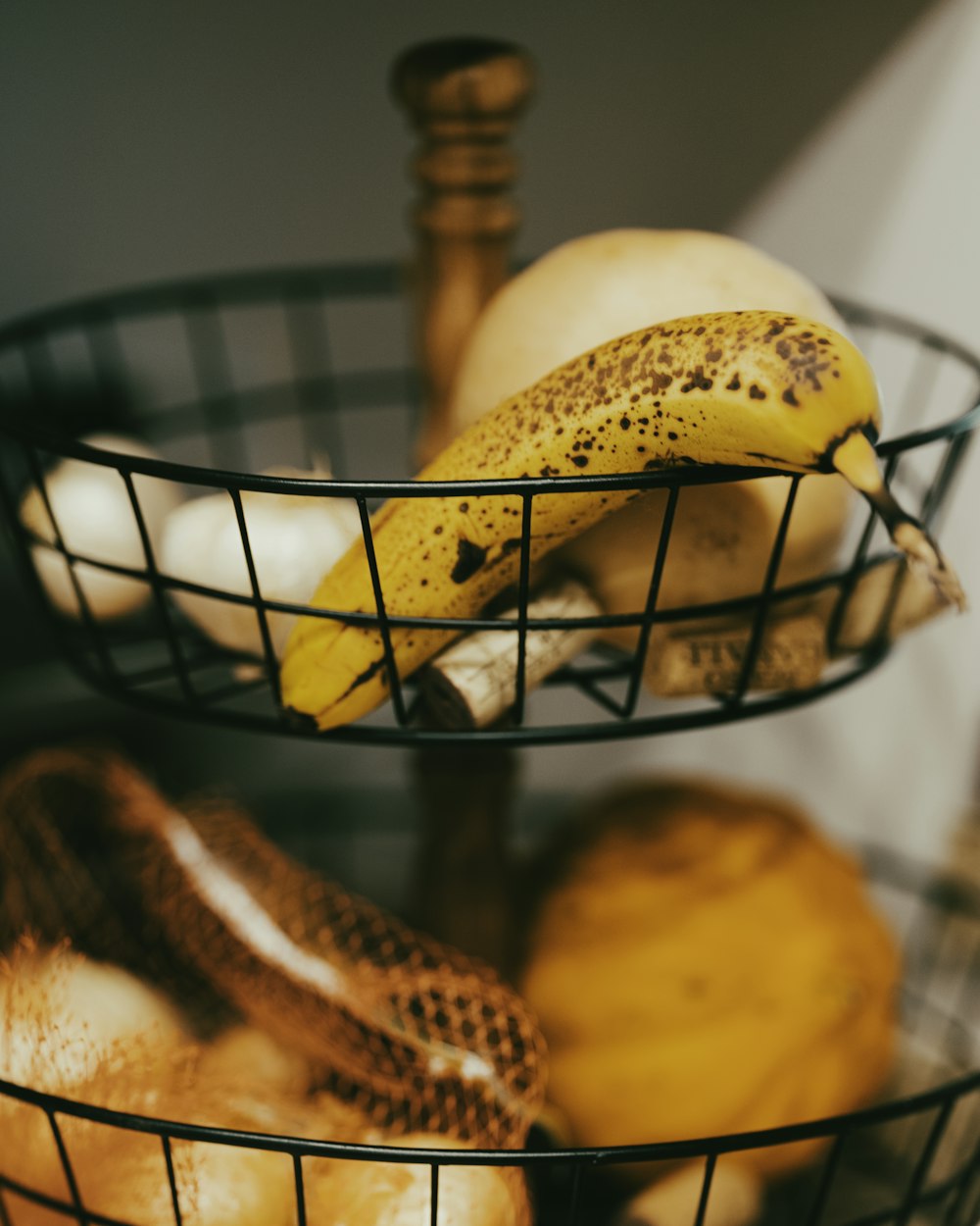 yellow banana fruit on black metal basket