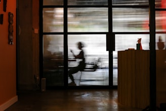 man in white t-shirt standing near window