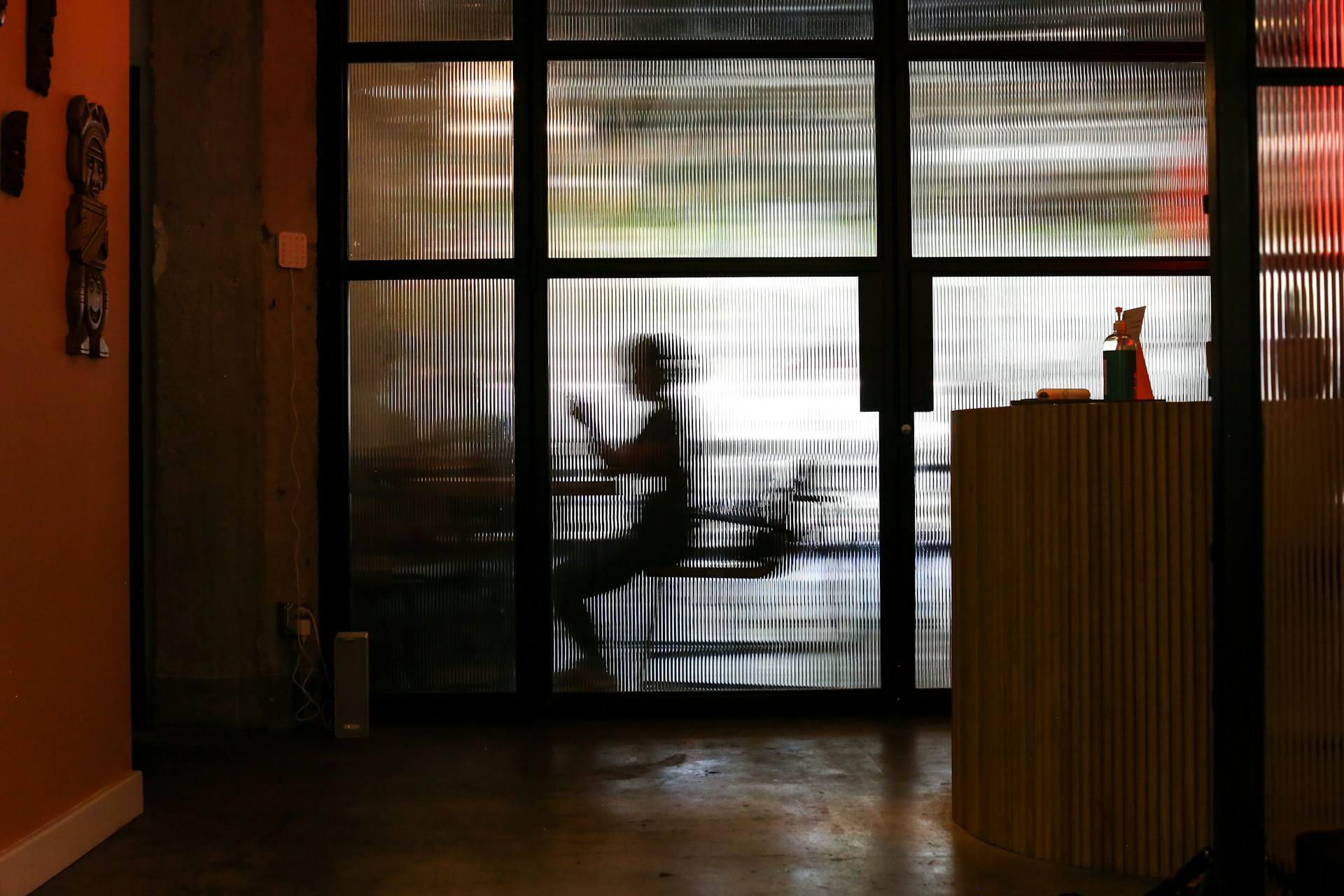 man in white t-shirt standing near window