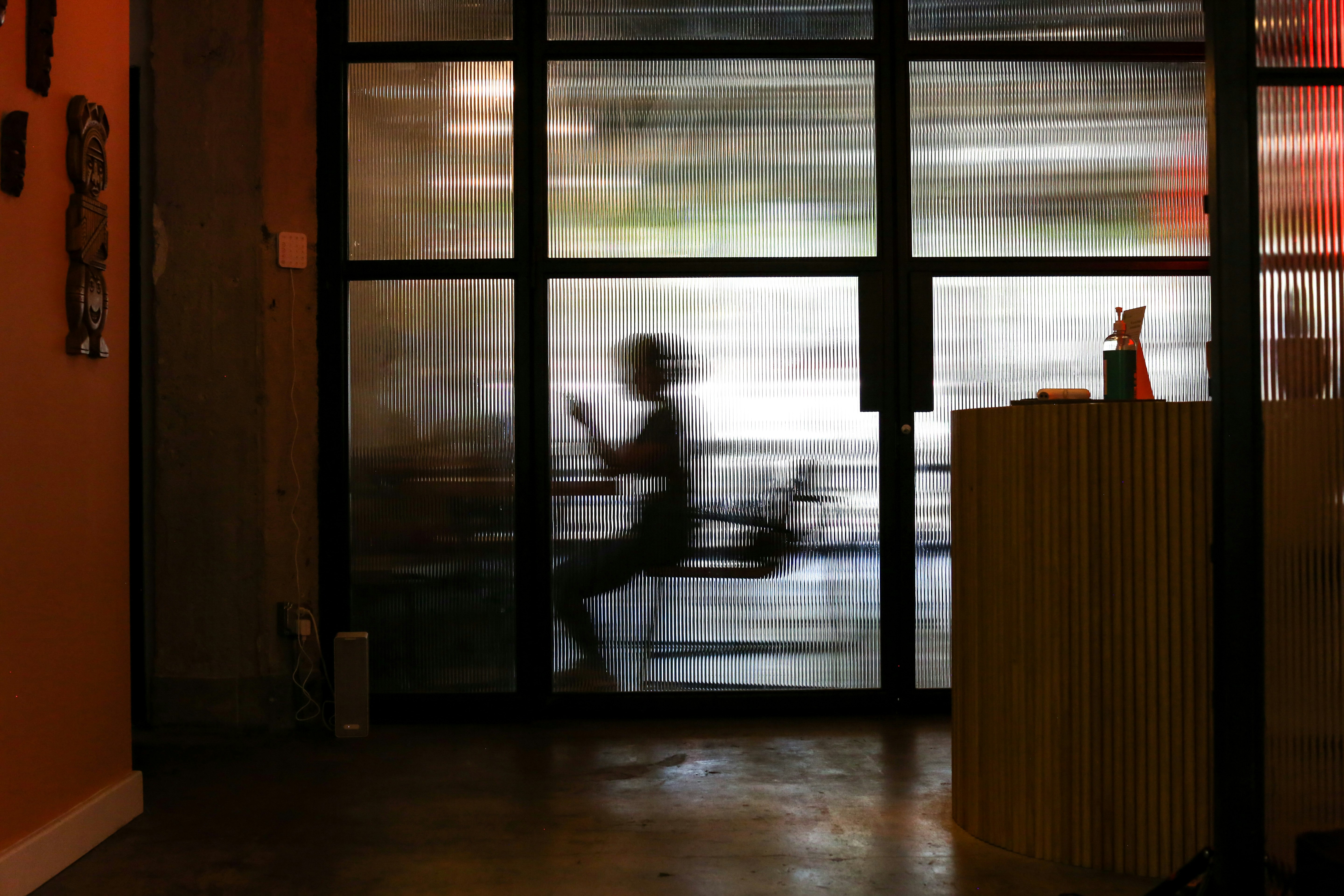 man in white t-shirt standing near window