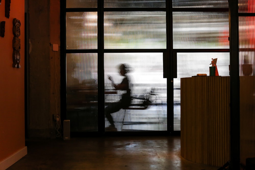 man in white t-shirt standing near window