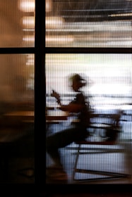 2 people sitting on chair near window during sunset