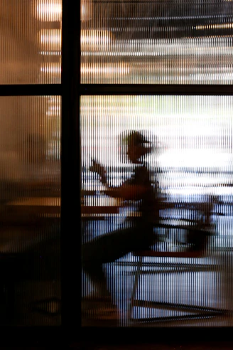 2 people sitting on chair near window during sunset