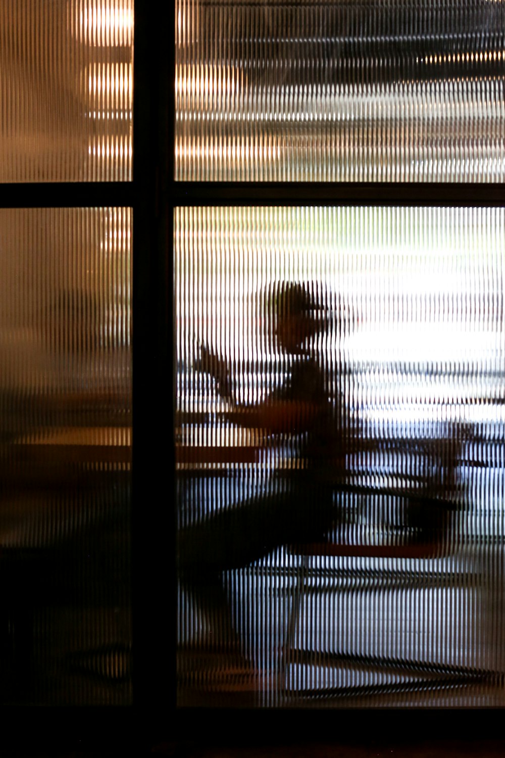 2 people sitting on chair near window during sunset