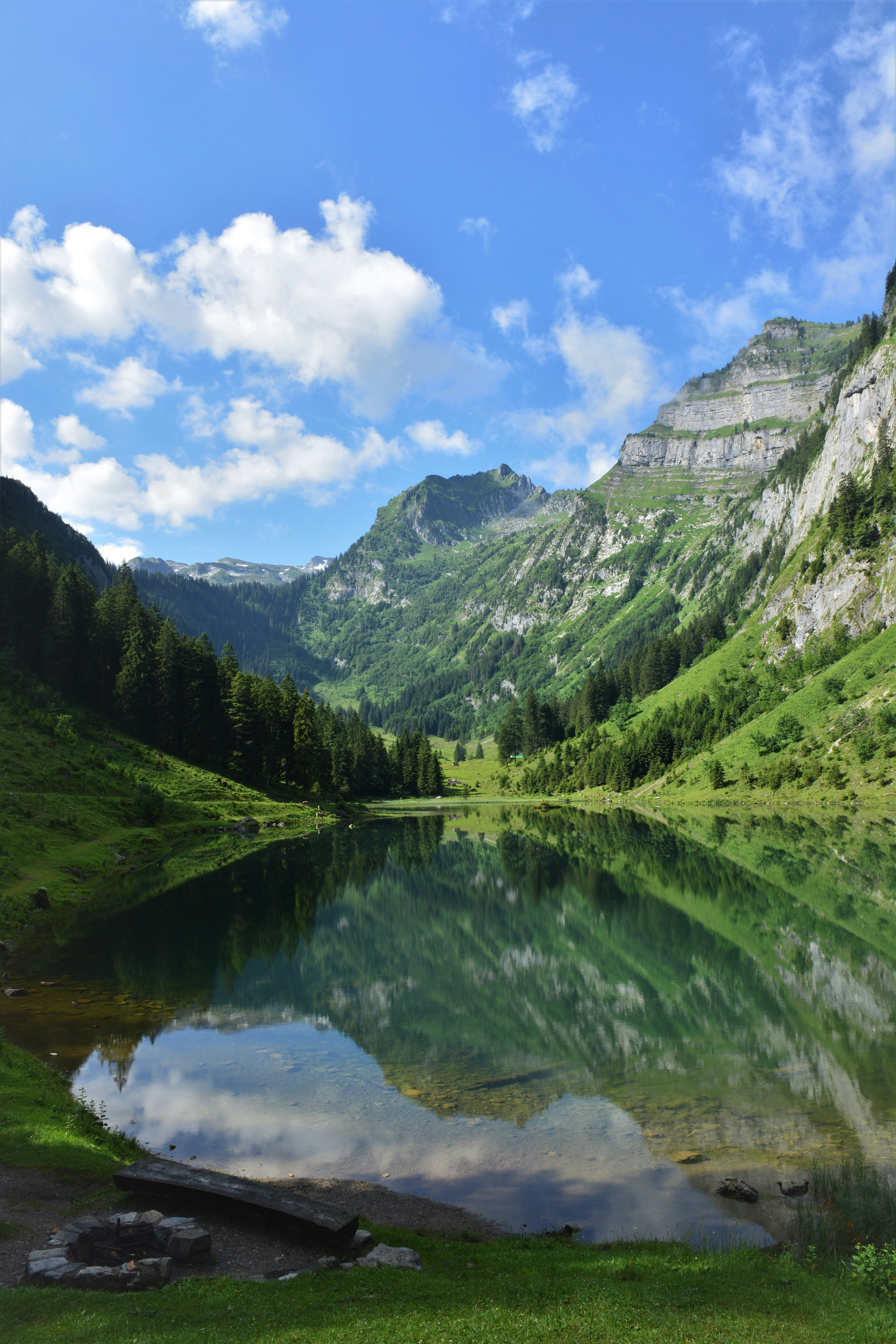 green mountains beside lake under blue sky during daytime