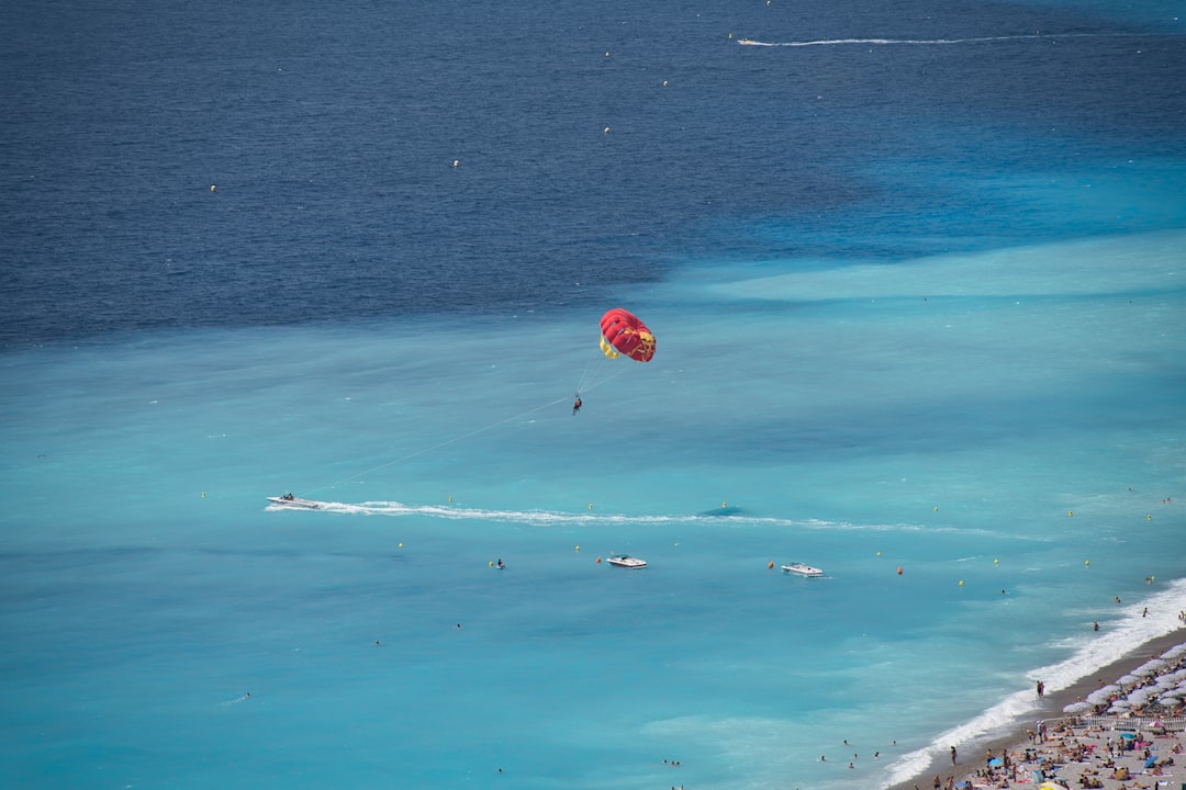 red and white balloon floating on blue sea during daytime