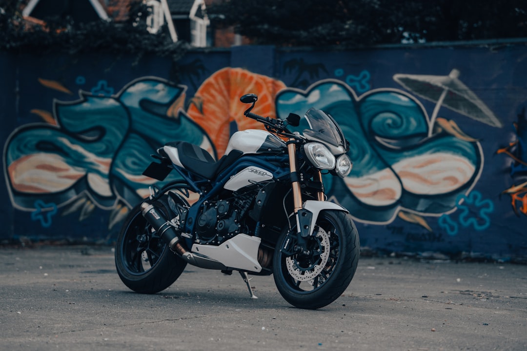 black and silver motorcycle parked beside wall with graffiti