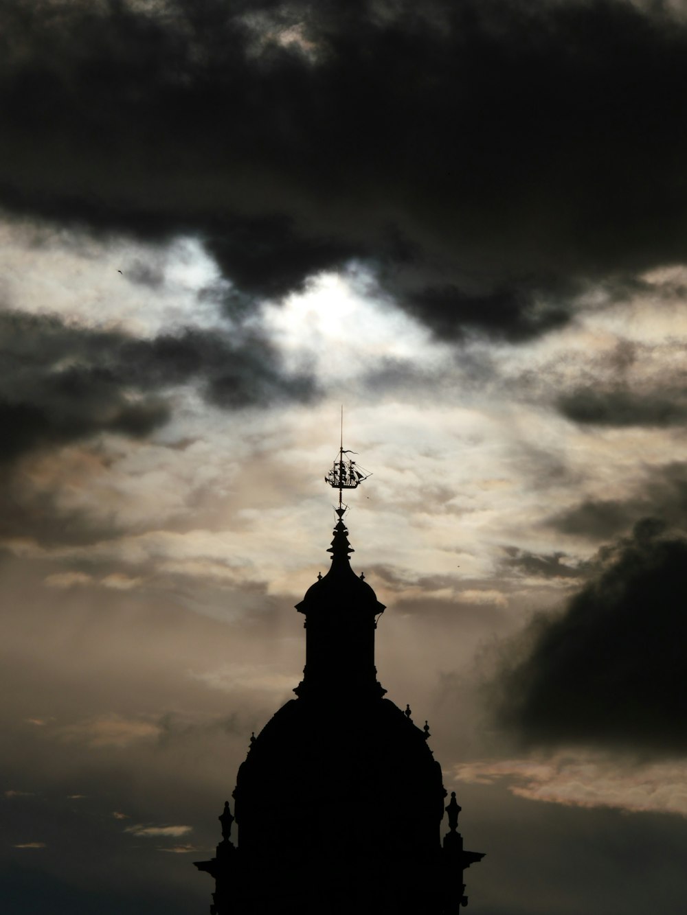 silhouette of building under cloudy sky during daytime