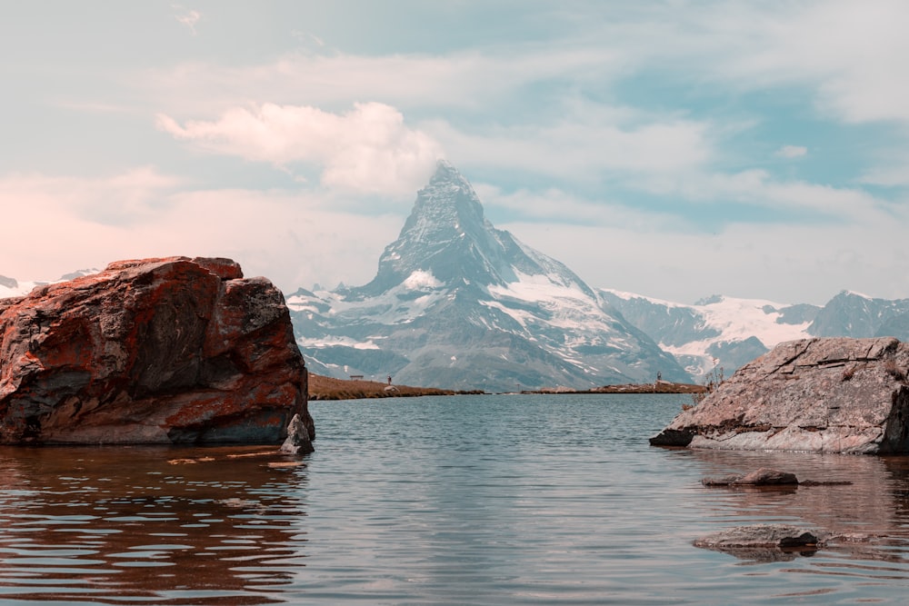 brown rock formation on body of water during daytime