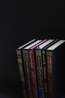 piled books on black surface