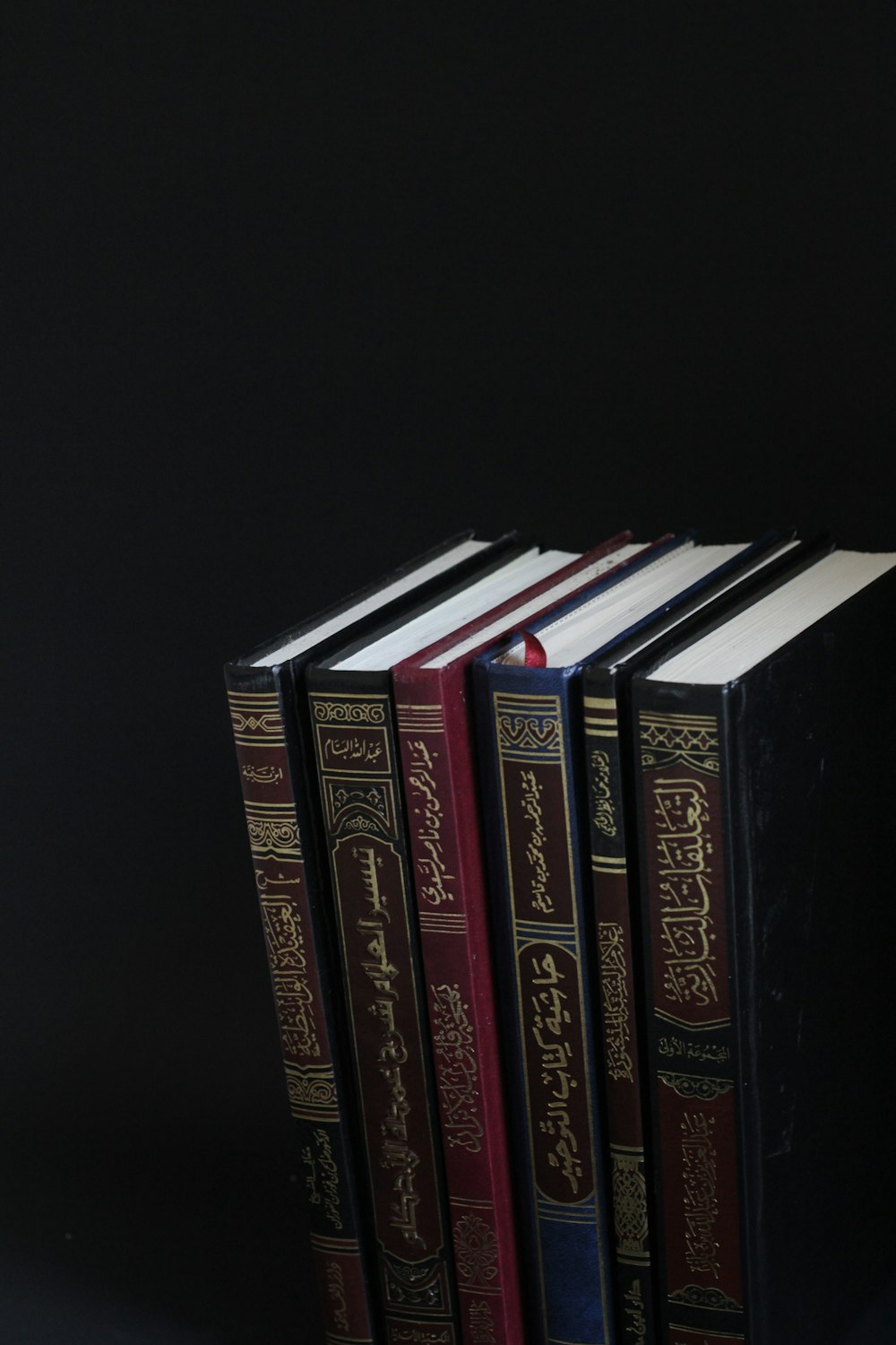 piled books on black surface
