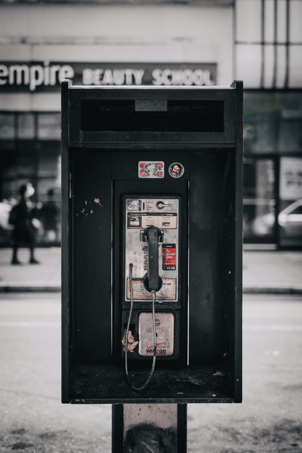 black telephone booth on sidewalk during daytime