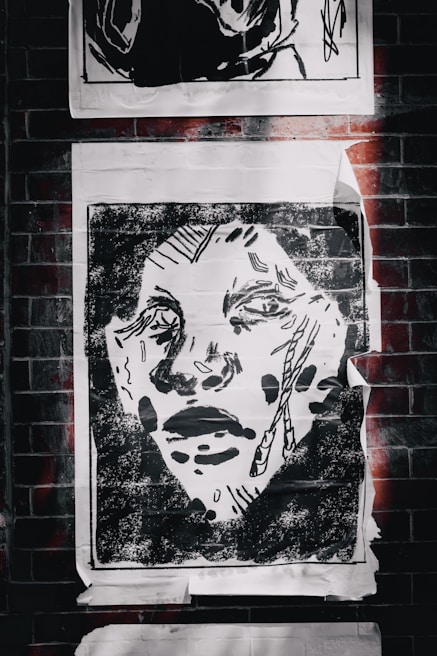 An artistic poster with bold colors and abstract shapes hanging on a white wall.