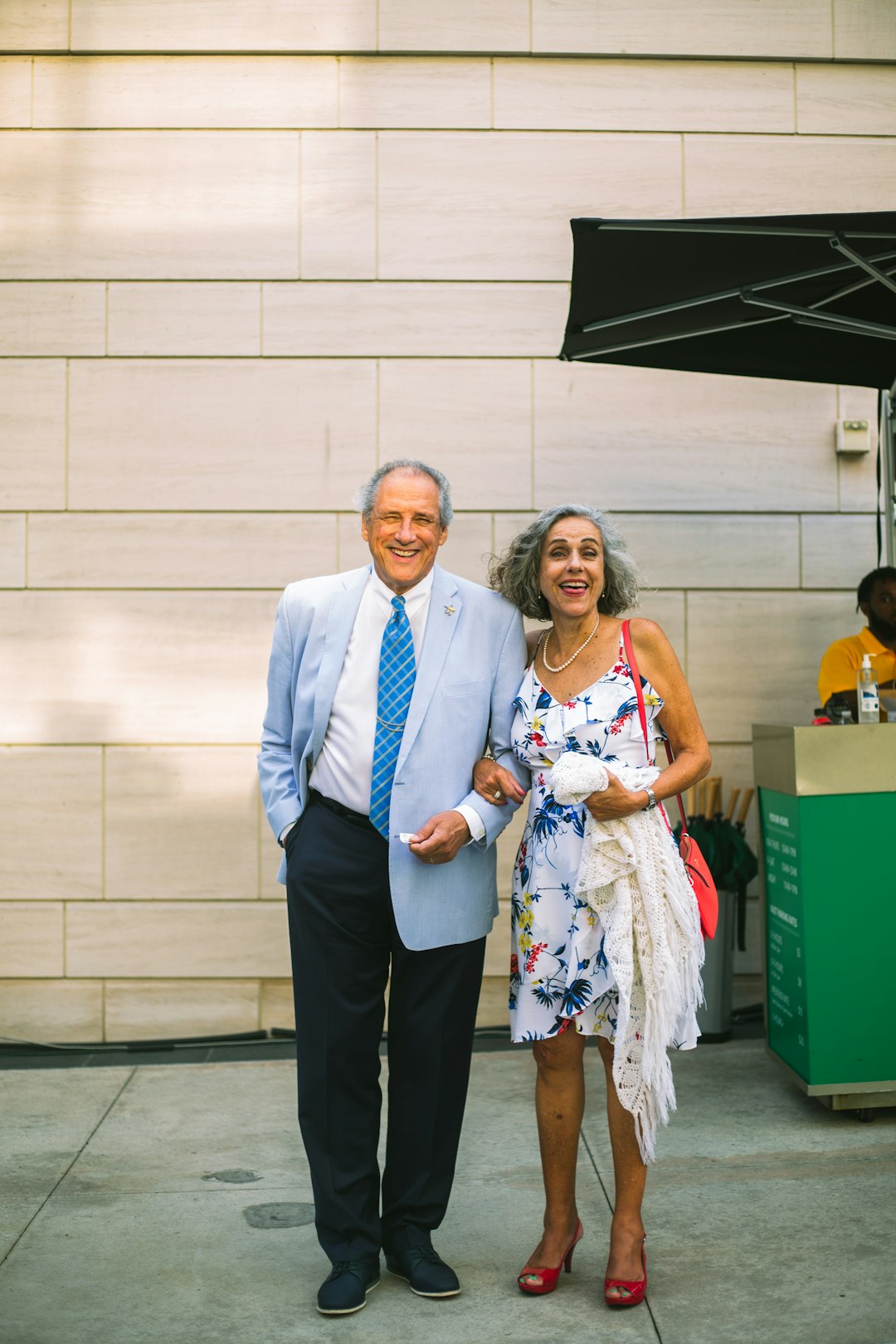 man in blue suit standing beside woman in white dress