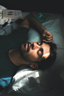 man in black crew neck t-shirt lying on bed