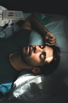 man in black crew neck t-shirt lying on bed
